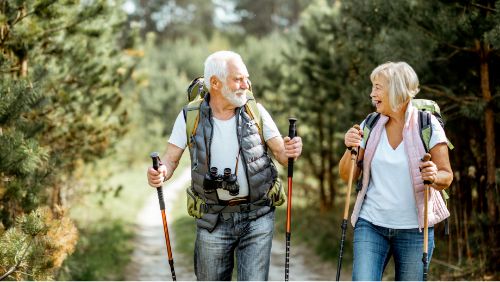 Mallorca for Seniors: Elderly couple walking through Mallorcan nature with walking poles.